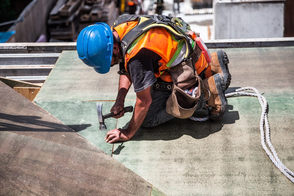 Worker in safety gear using a hammer
